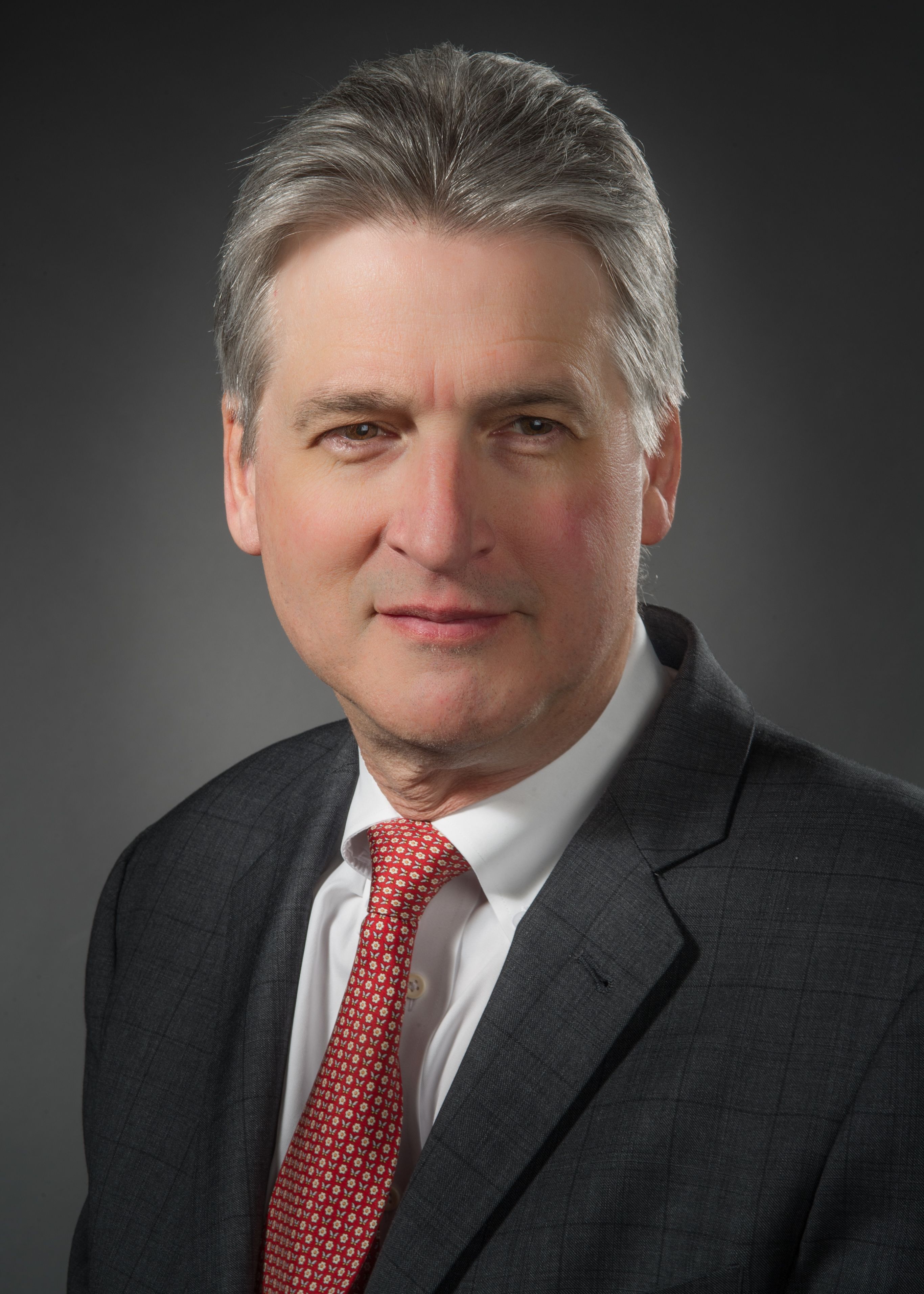 Martin Doerfler, MD, wearing a suit and a red tie